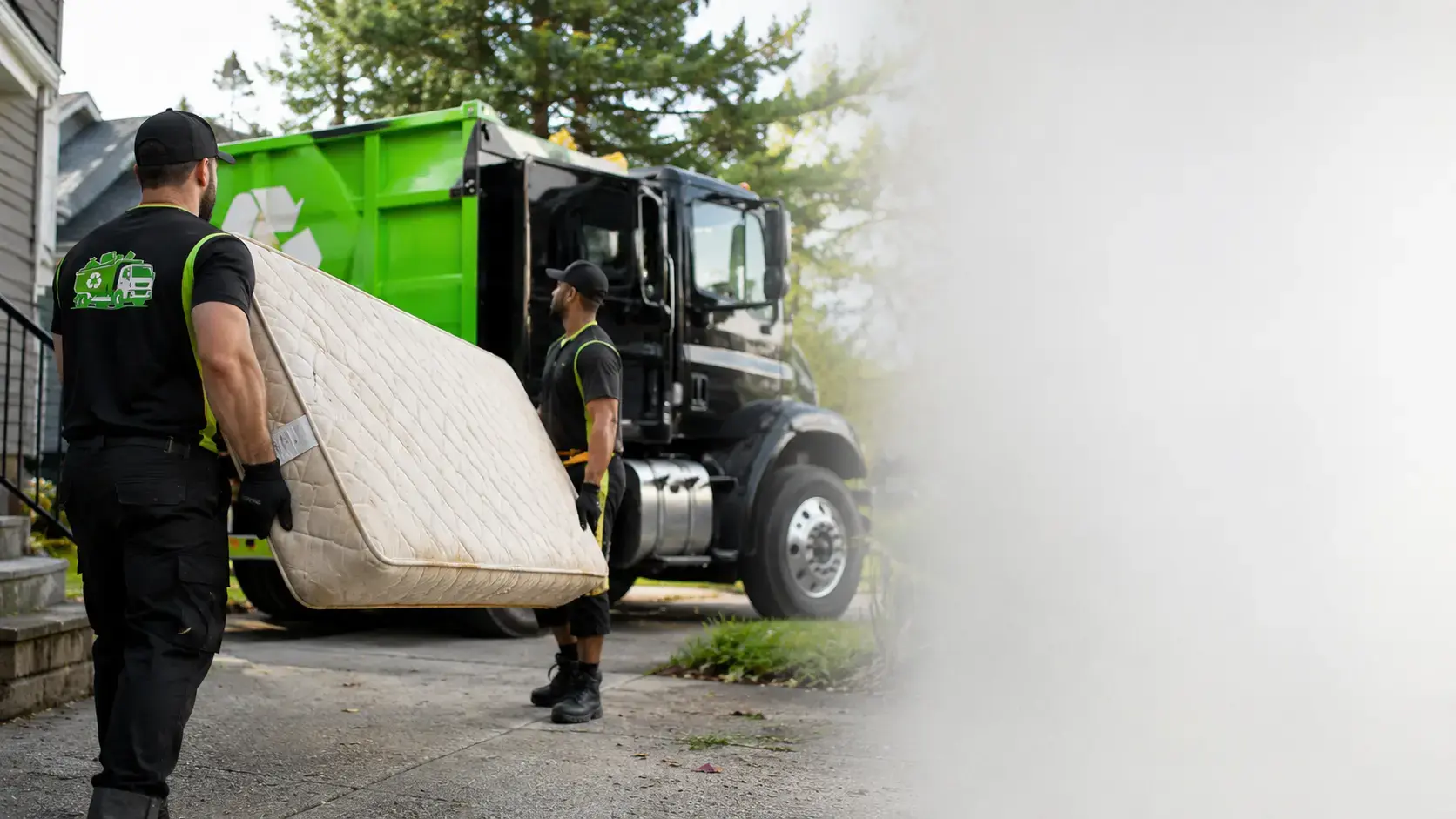 Mattress removal crew preparing an old mattress for disposal in a United States residential cleanout